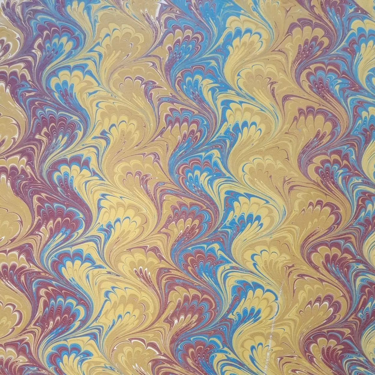 Handmarmoriertes Papier mit klassischer Kammstruktur in Blau- und Goldtönen, feine Linienführung