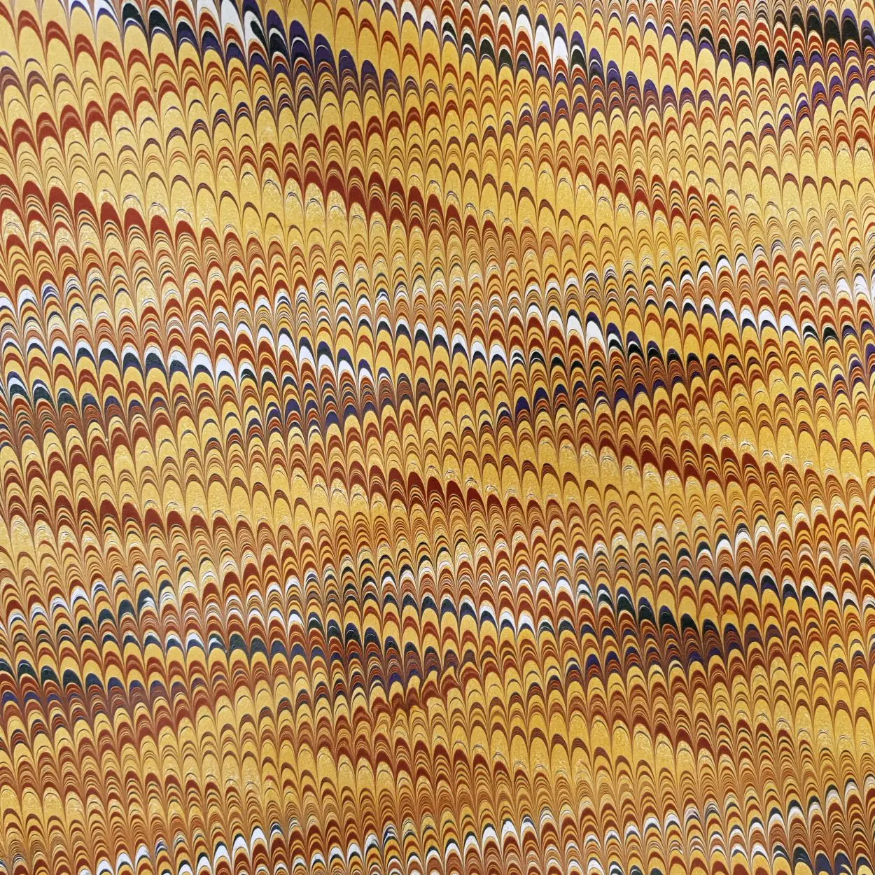 Handmarmoriertes Papier mit feiner Kammstruktur in Gold- und Brauntönen, traditionelles Marmoriermuster