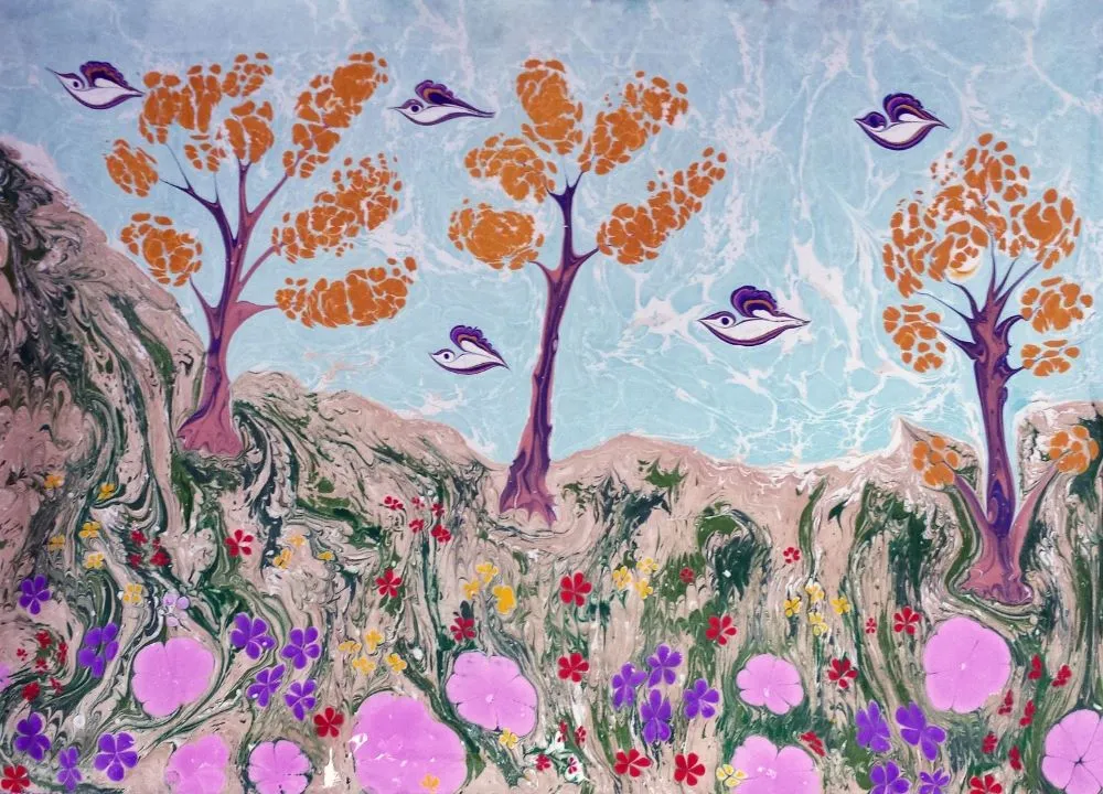Eine abstrakte Naturlandschaft, die mit der Ebru-Technik geschaffen wurde. Grüne Hügel, bunte Blumen und Bäume in traditioneller türkischer Wasser-Maltechnik.
