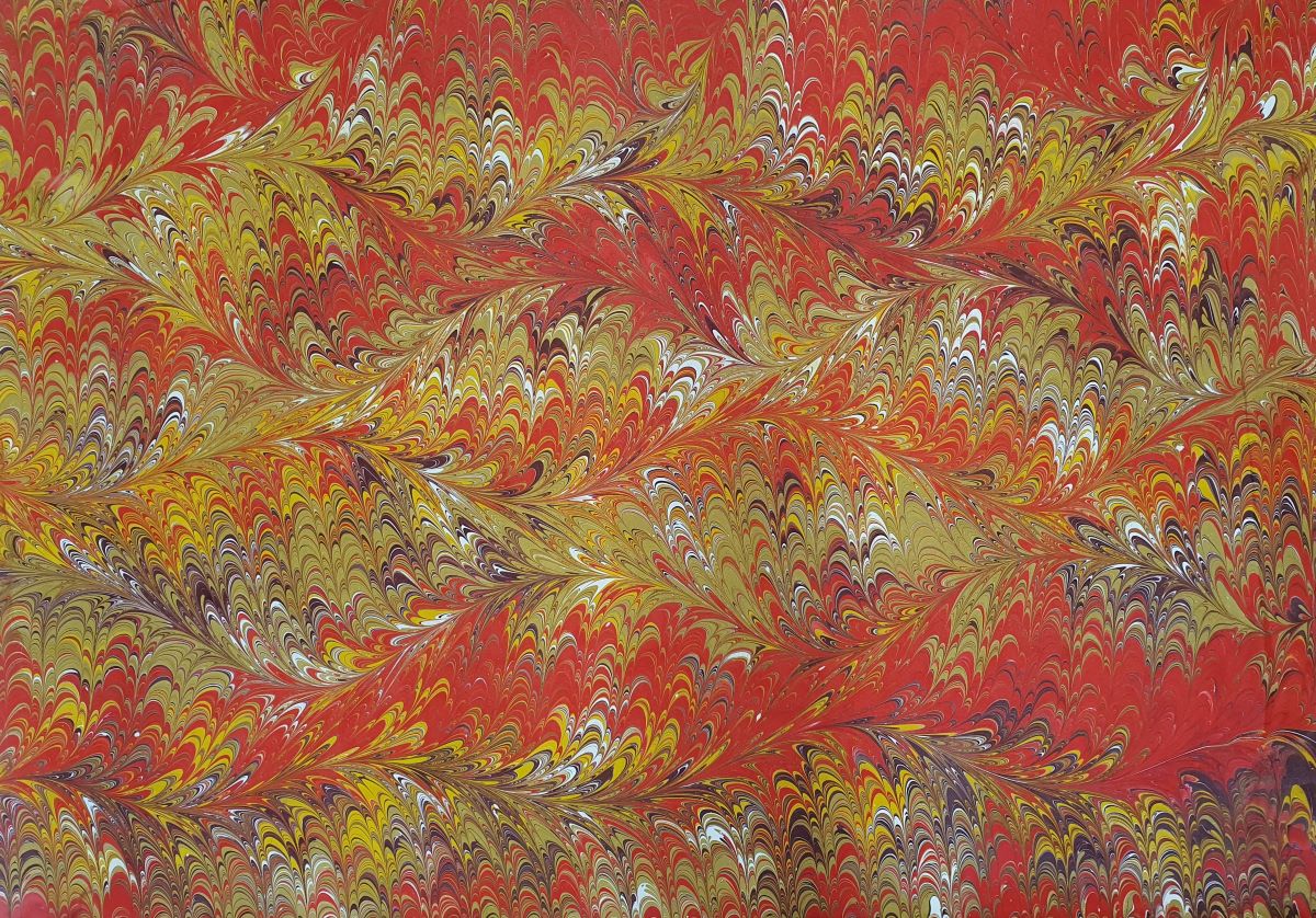 Handgemachtes marmoriertes Papier in Rot-Gold mit Wellenblatt-Muster – ideal für kreative Anwendungen.